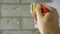 A construction worker applies paint to a brick wall.The painter paints primers the walls with a brush, makes repairs in the house