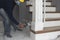 A construction worker applies varnish on the stairs. Using an airbrush for the application. Renovation or finishing works