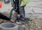 Construction worker breaking concrete around road gully using hydraulic breakers during road works on  housing development