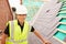 Construction Worker On Building Site Laying Slate Tiles