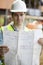 Construction Worker On Building Site Looking At House Plans