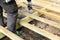 Construction worker building wooden frame for terrace deck