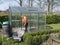 Construction worker cleaning filth with high pressure cleaner from a glass greenhouse