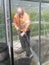 Construction worker cleaning filth with high pressure cleaner from a glass greenhouse