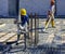 Construction worker compacting liquid cement in reinforcement form