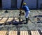 Construction worker compacting liquid cement in reinforcement form