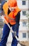 Construction worker digging sand with shovel