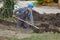 Construction worker digging trench using shovel