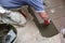 The construction worker evenly spreads the surface of the stairs with cement adhesive mass using a special hand tool.