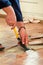 Construction worker and Handyman is removing old wooden parquet flooring using yellow hammer and scraping tool.