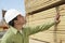 Construction Worker In Hardhat Inspecting Lumber