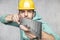 The construction worker is holding a angle in the hand, a guide to constructing right angles