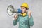 The construction worker holds a megaphone in his hands, the concept of issuing orders