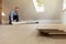 Construction worker installing laminate floor in a new renovated attic. Home improvement concept