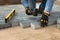 Construction worker laying cement pavement on a walkway with gloves and rubber hammer. House improvement