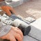 Construction worker laying stone cobbles in sand