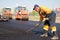 Construction worker levelling fresh asphalt