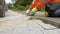 Construction worker makes new sidewalk pavement with stone bricks