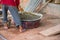 Construction worker manually mixing concrete in mixer tray