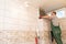 A construction worker measures and prepares to cut ceramic tiles