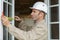 Construction worker measures window frame