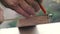 Construction worker measuring board. Close-up. A carpenter measures a wooden bar using a tape measure.