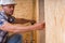 Construction Worker Measuring Width of Door Frame