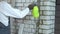 Construction worker moisturing brick wall with water sprayer