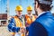 Construction worker in protective uniform shaking hands with businessman