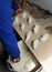 Construction worker putting white porcelain stoneware tiles in the kitchen