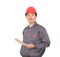 A construction worker with a red hard hat is holding an iPad in hand while standing in front of a white background and looking at