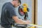 Construction worker remodeling home Carpenter cutting wooden trim board on with circular saw