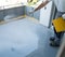 Construction worker renovates balcony floor and spreads chip floor covering on resin and glue coating before applaying water
