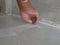 A construction worker`s hand puting tile grout on to the laid ceramic tiles on the floor - tiling work