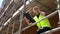 Construction worker on scaffolding with a clipboard and talking on cell phone