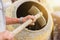 Construction worker shovels the sand into the concrete mixer. process of creating cement on the construction site