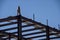 A construction worker on the the top of an iron beam framing of a commercial building under construction