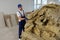 Construction worker with used glass wool in room prepared for renovation