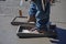 A construction worker uses sliding boards on a wet concrete slab.