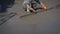 Construction worker using long triangle trowel to plastering cement on the floor