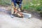 A construction worker using a portable cutter cuts asphalt to repair a worn section of the roadway