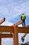 Construction worker walks on beams of a wood building