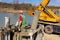 Construction worker washing separated metal pump tube, canal of fresh concrete