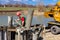 Construction worker washing separated metal pump tube, canal of fresh concrete