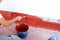 Construction worker waterproofing the terrace of a building with red acrylic rubber paint