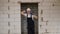 Construction worker in a white hard hat stands in the doorway of a new apartment