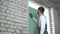 Construction worker writing with pencil on plasterboard