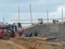 Construction workers finish bridge ramp retaining wall