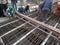 Construction workers are installing steel rods in reinforced concrete post tension site concrete steel