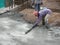 Construction workers leveling wet concrete has been poured.